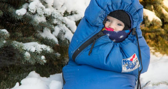 Photo d'un bébé dans un sac-anorak en hiver sous la neige Jewpop